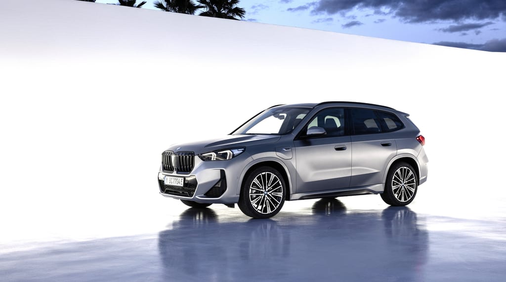 BMW X1 אפור מטאלי, מבט שלושת־רבעי קדמי על במת סטודיו כהה