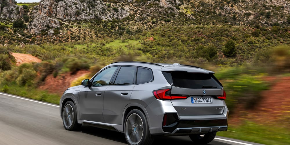 BMW X1 אפור מטאלי, מבט שלושת־רבעי אחורי בכביש